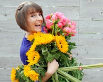 Beth Cayton, a McNamara Customer Service Representative, with an armful of bright spring flowers